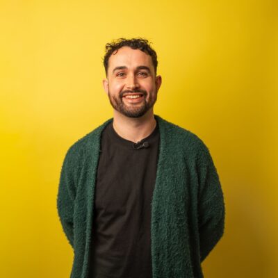 Daragh smiling against yellow background