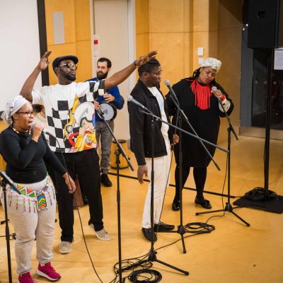 A group of musicians on stage singing.