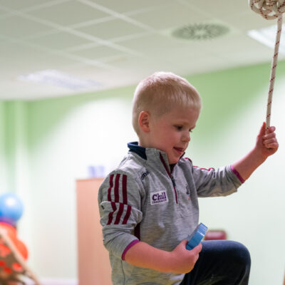 Small boy interacting with female care staff member and using tactile play items