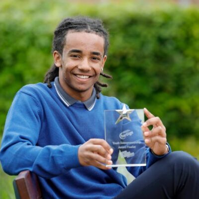 Student smiling and holding an award