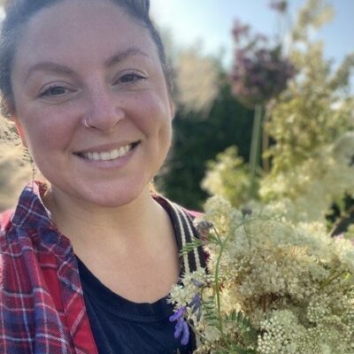 Lady smiling in the outdoors surrounded by foliage