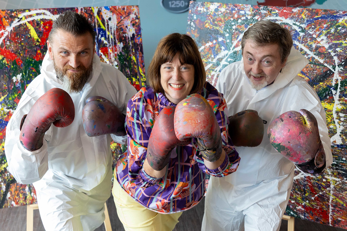 2 men and 1 woman in a fighting pose wearing boxing gloves