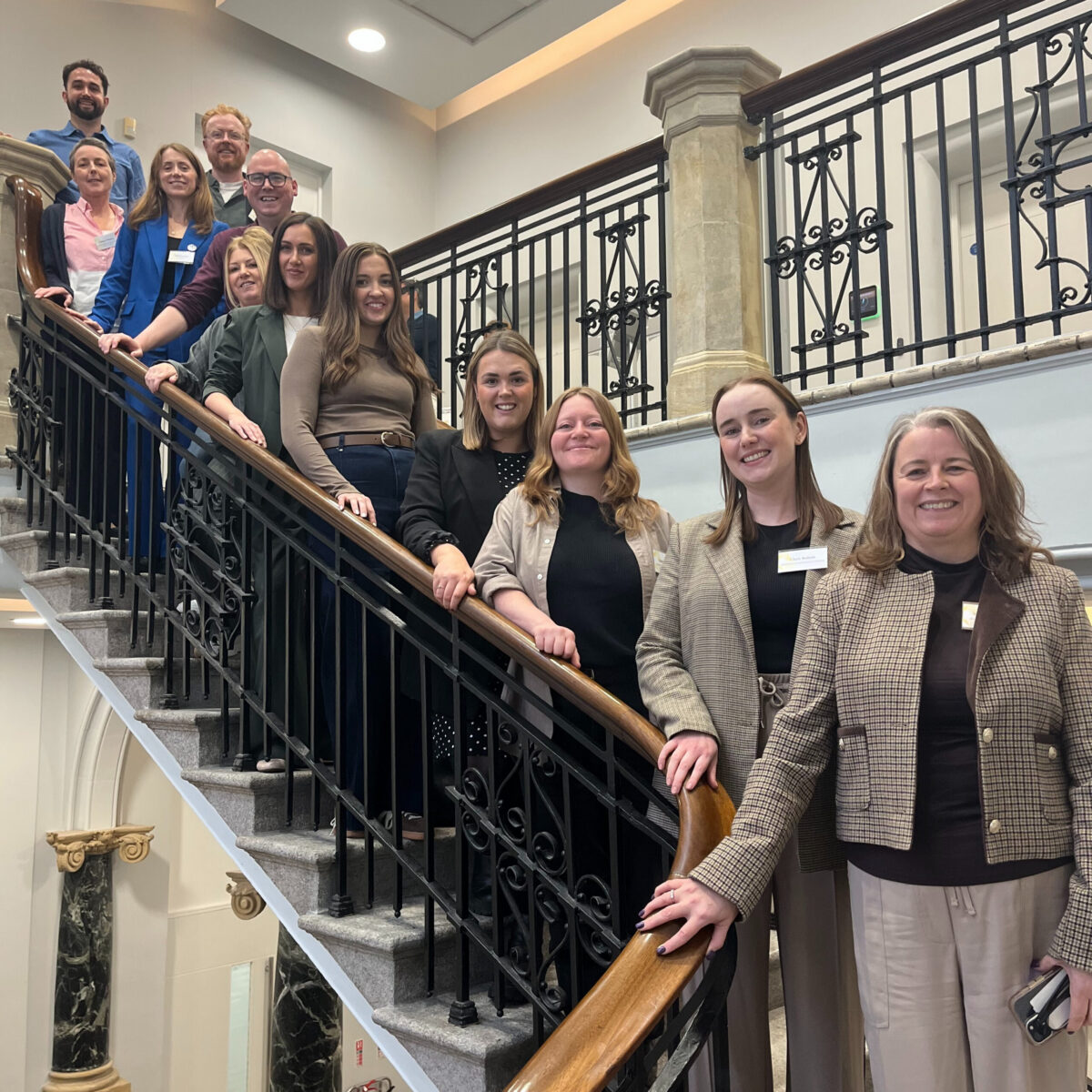Group of people standing up along a staircase