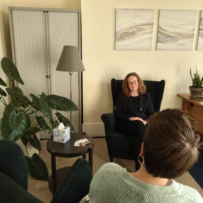 A woman sitting in a chair facing a client