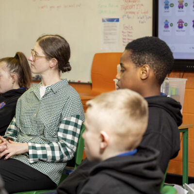2 older children sitting in a classroom