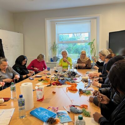 group of people sitting around a table working on crafts
