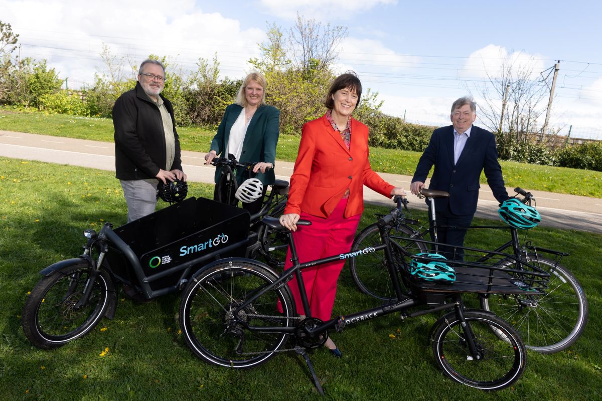 Picture of 2 women and 2 men holding bikes in a park setting