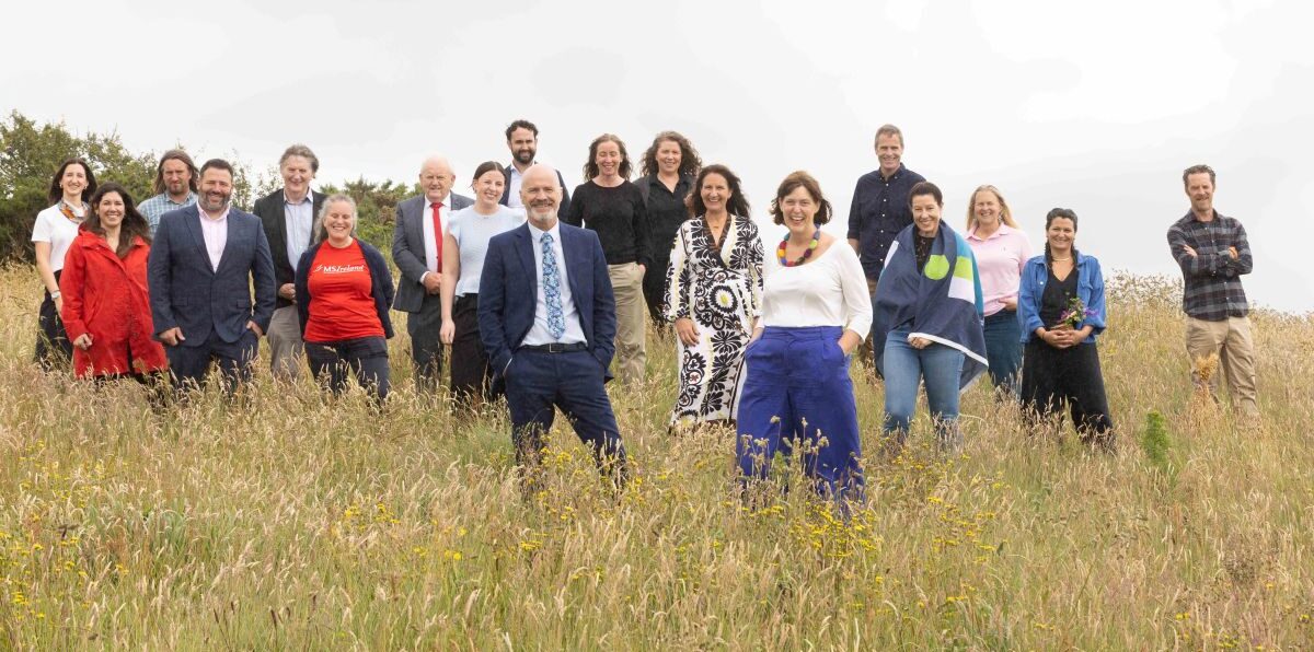 Group of men and women standing in a meadow