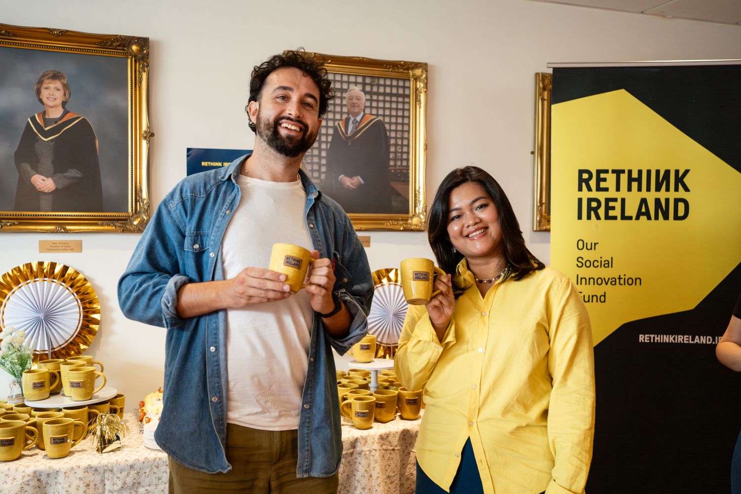 Two people smiling with Rethink Ireland mugs